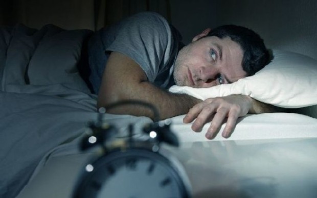 man in bed with eyes opened suffering insomnia and sleep disorder