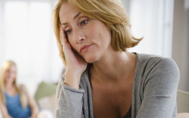 Worried mother, teenage daughter in background