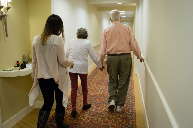 ROCKVILLE, MARYLAND - OCTOBER 22:  Maggie Gonzalez, 25, takes care of her grandparents, John L. and Susan duFief, both 85, at least 12 hours per week and sometimes more. Gonzalez walks down the hallway of her grandparents apartment building. (Photo by Sarah L. Voisin/The Washington Post via Getty Images)