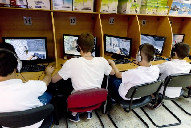 epa04216065 Palestinian teenager play a computer game in an internet cafe in the Old City of Jerusalem, Israel, 20 May 2014. The video game, a so-called 'First-person shooter' or 'ego-shooter' is based on shooting 'terrorists.'  EPA/JIM HOLLANDER